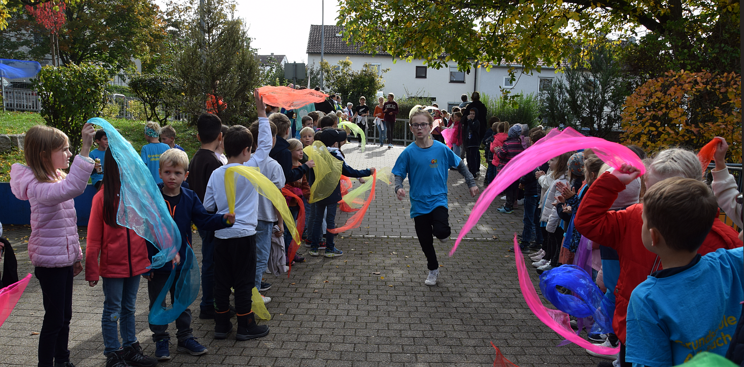 Fot vom Zieleinlauf mit Spalier stehenden Kindern und einem Läufer-Kind